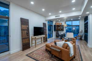 Living room featuring recessed lighting, wood finished floors, and a wall of windows