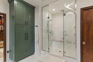 Full bath with a stall shower, tile patterned floors, and a closet