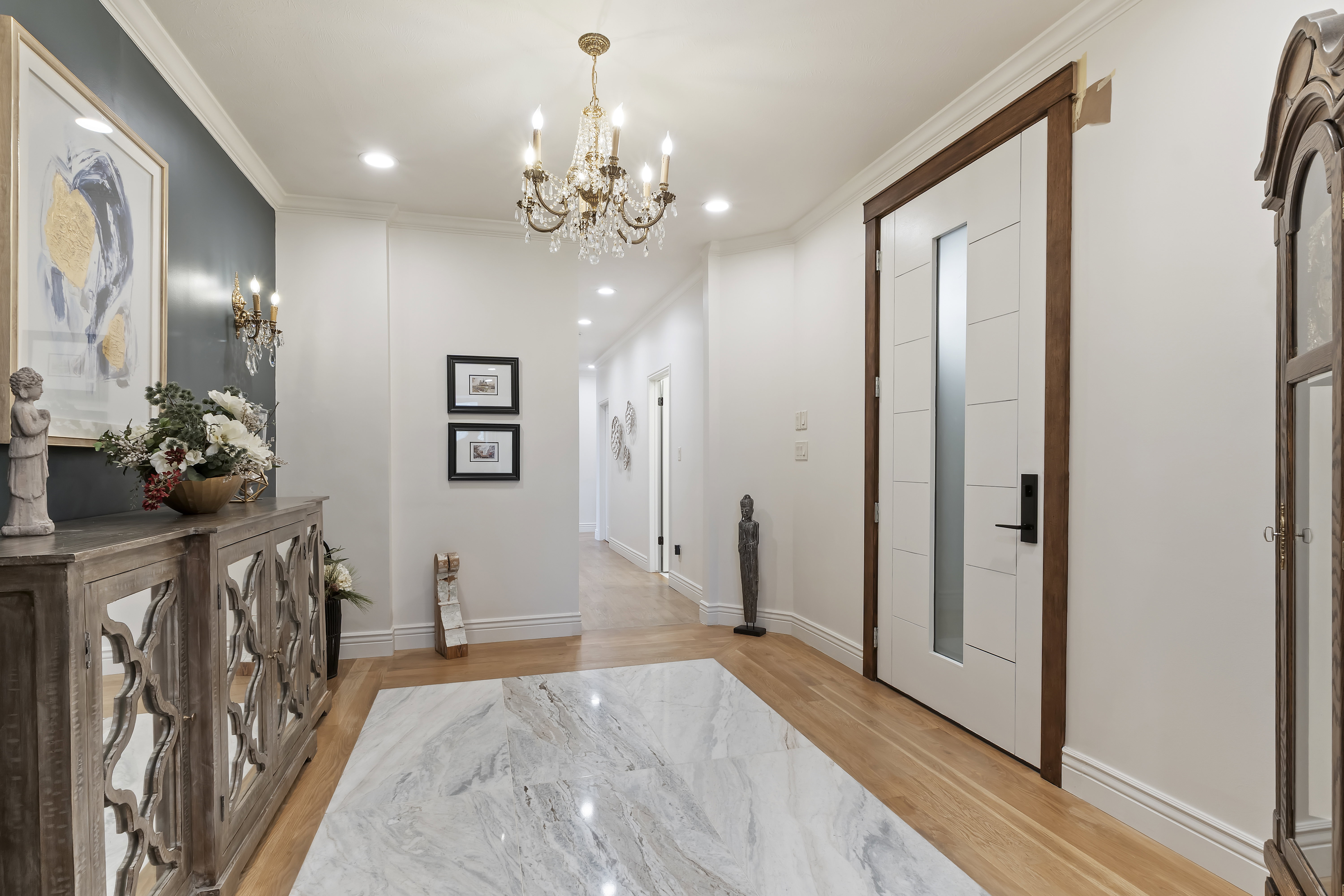 Hallway featuring crown molding, light wood-type flooring, recessed lighting, and a chandelier