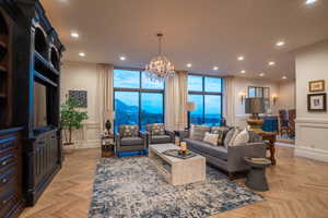 Living area with recessed lighting, a chandelier, a wainscoted wall, a mountain view, and a decorative wall