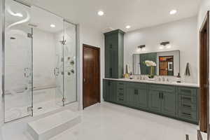 Bathroom featuring double vanity, a stall shower, recessed lighting, and tile patterned flooring