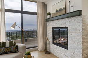 Living area featuring wood finished floors, a fireplace, and a wall of windows