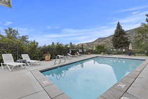 Community pool featuring a mountain view and a patio area