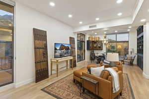 Living area with recessed lighting, light wood-style flooring, and a fireplace