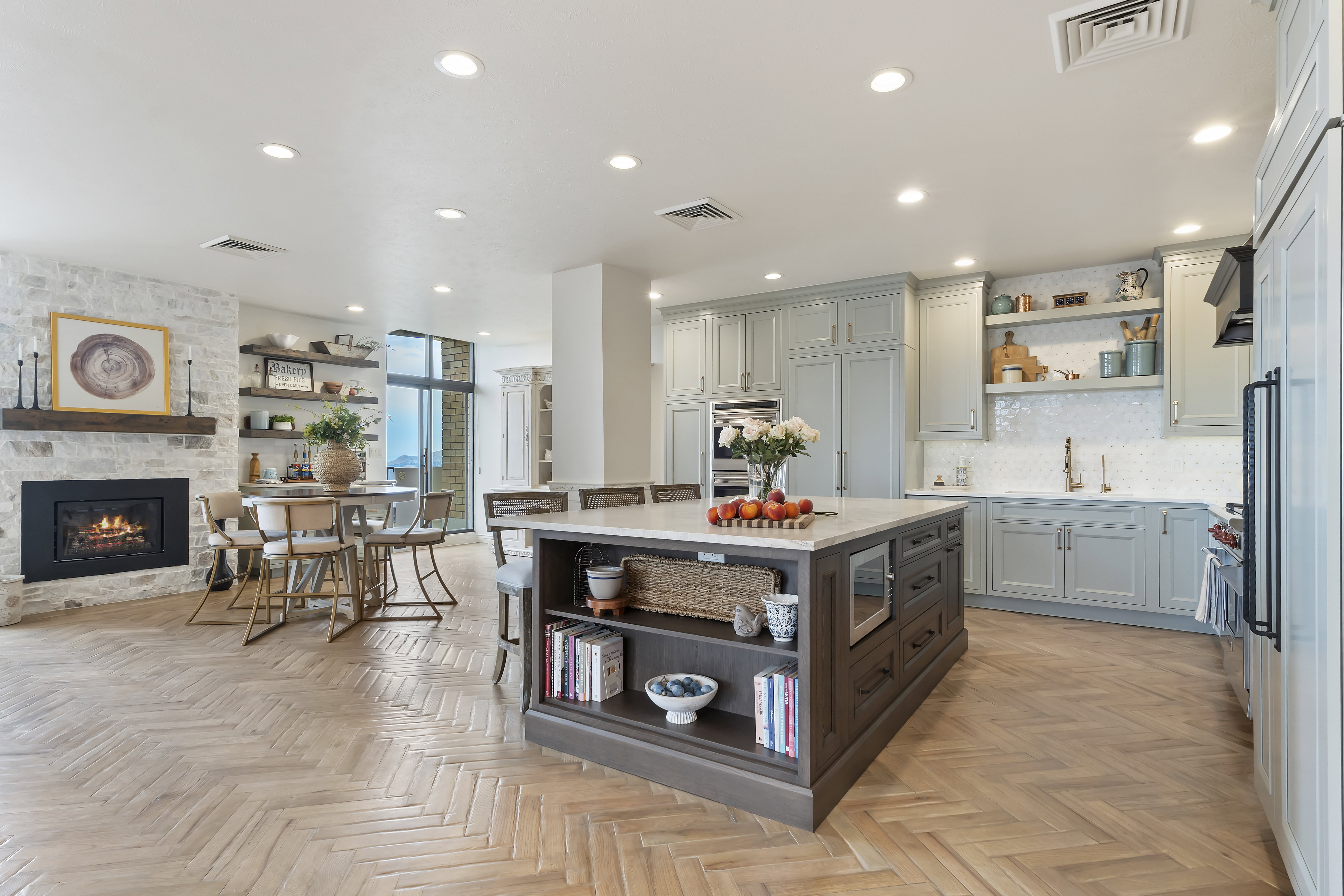 Kitchen with open shelves, light countertops, recessed lighting, a stone fireplace, and decorative backsplash