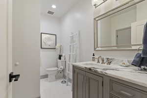 Bathroom featuring vanity, tile patterned flooring, and recessed lighting