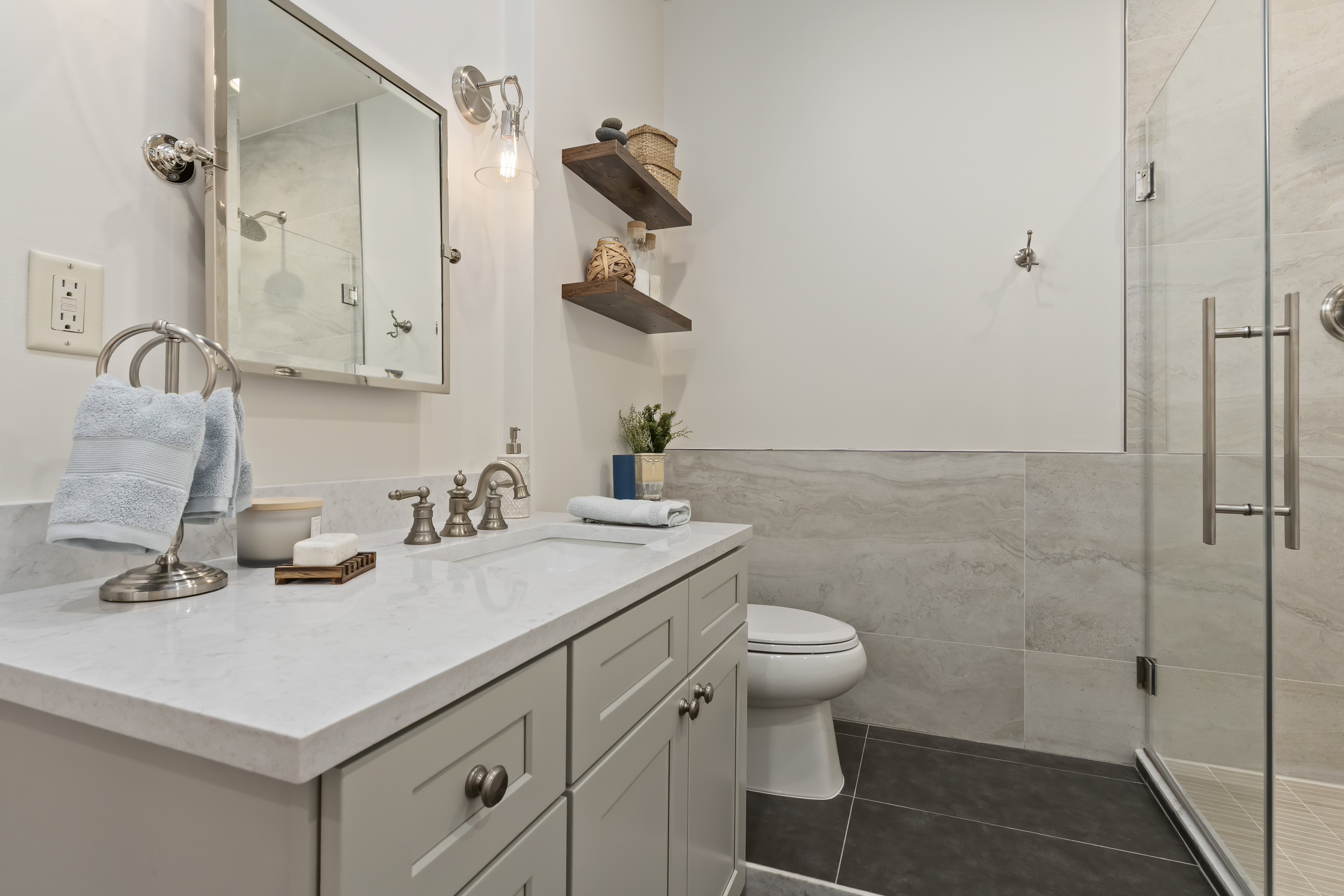 Full bathroom featuring tile walls, vanity, a shower stall, tile patterned floors, and wainscoting