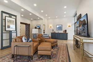 Living area with light wood-style flooring and recessed lighting