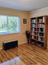 Living area featuring ornamental molding and wood finished floors