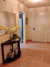 Entrance foyer featuring ornamental molding and light tile patterned floors