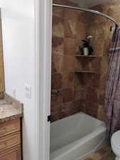 Full bathroom with shower / tub combo with curtain, vanity, and tile patterned flooring