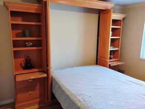 Bedroom with dark wood-style floors and crown molding