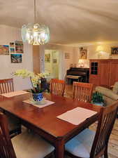 Dining area with light wood-style flooring, ornamental molding, and a chandelier
