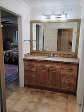 Bathroom with ensuite bathroom, ornamental molding, and vanity