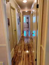 Hallway featuring hardwood / wood-style flooring and crown molding