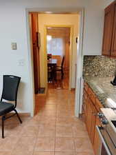 Corridor featuring light tile patterned flooring and baseboards