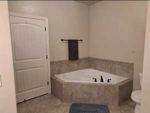 Full bath with a garden tub and tile patterned floors