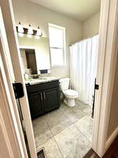 Full bath featuring vanity and light tile patterned floors
