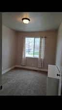 Unfurnished room featuring carpet and a textured ceiling