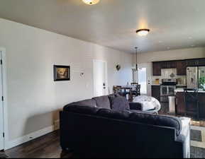 Living area with dark wood-style floors and baseboards