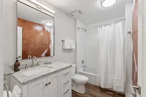 Bathroom featuring vanity, wood finished floors, and shower / tub combo