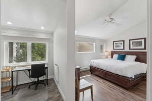 Bedroom with lofted ceiling, a desk, a baseboard heating unit, recessed lighting, and ceiling fan