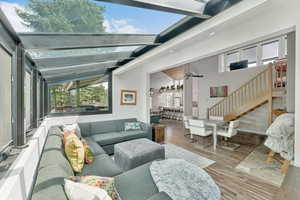 Living area with wood finished floors, stairs, ceiling fan, and beamed ceiling