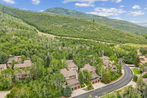 Aerial view of property and surrounding area with a mountainous background and nearby suburban area