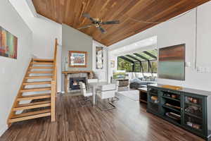 Living area featuring wood ceiling, wood finished floors, stairs, a high end fireplace, and lofted ceiling