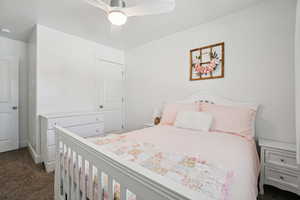 Bedroom with dark carpet and a ceiling fan