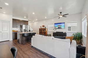 Living room with dark wood-style floors, ceiling fan, and recessed lighting