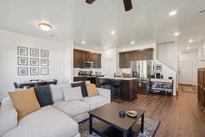 Living room featuring dark wood finished floors, a ceiling fan, and recessed lighting