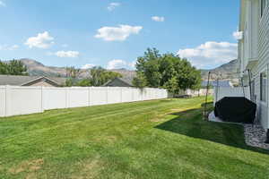 Fenced backyard featuring a mountain view
