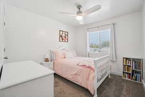 Bedroom featuring dark colored carpet and ceiling fan