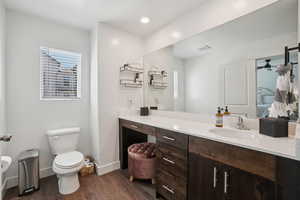 Full bath with vanity, dark wood-style flooring, ensuite bathroom, and recessed lighting