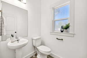 Half bathroom with toilet and baseboards
