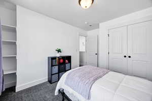 Carpeted bedroom featuring baseboards and a closet