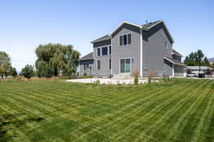 Rear view of house featuring a patio area and a lawn