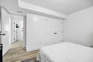 Bedroom with light wood-style flooring and a closet