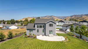 Rear view of property featuring a patio, a residential view, a mountain view, entry steps, and a fenced backyard