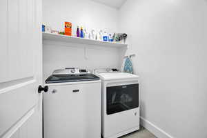 Laundry area with washer and dryer and baseboards