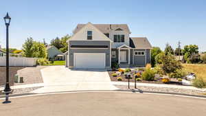 View of front of house with concrete driveway, a garage, and a shingled roof