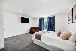 Bedroom featuring carpet flooring and baseboards
