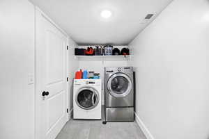 Laundry area featuring separate washer and dryer and baseboards