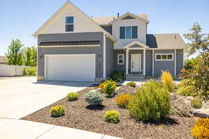 View of front of home featuring concrete driveway, a shingled roof, and a standing seam roof