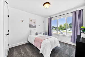 Bedroom featuring dark colored carpet