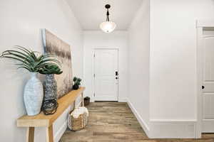 Entryway with wood finished floors and baseboards