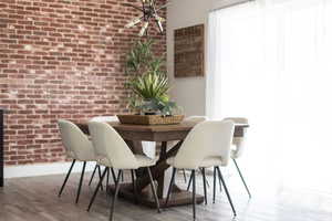 Dining room with brick wall and wood finished floors