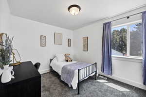 Bedroom with dark carpet and baseboards