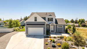 View of front of home featuring driveway, roof with shingles, and a garage